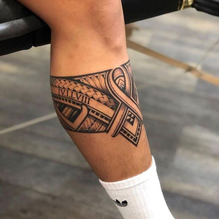 a man's leg with a tattoo on it that has a cross in the middle