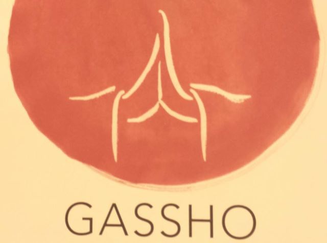 there is a sign that says gassho on the front and back side of it