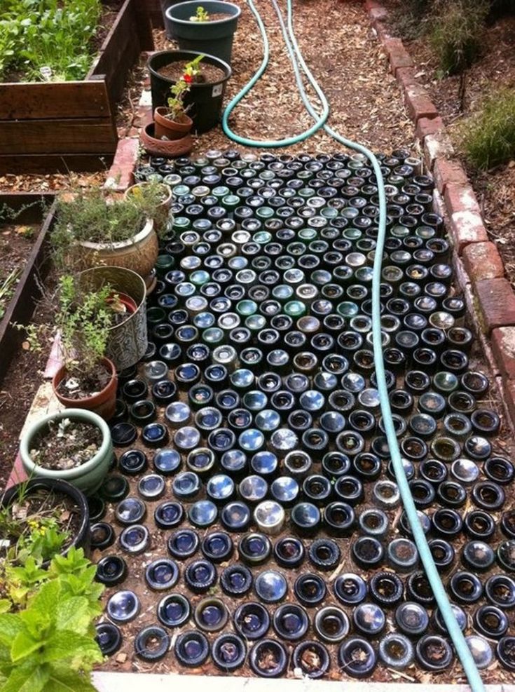 the garden is filled with pots and hoses to water it's planters