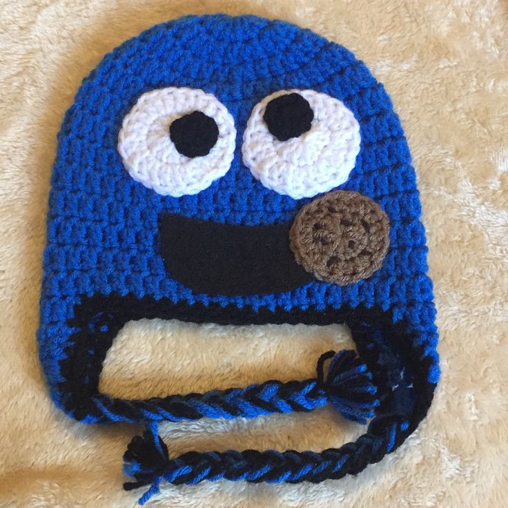 a crocheted blue hat with eyes and braids