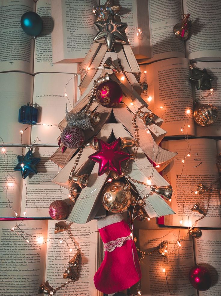 a christmas tree made out of books and ornaments