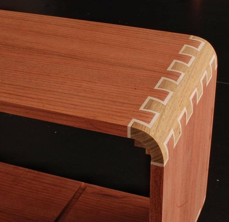 a close up of a wooden shelf on a black surface with wood grained edges