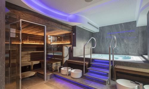 an indoor hot tub and sauna with stairs leading up to the bathtub area