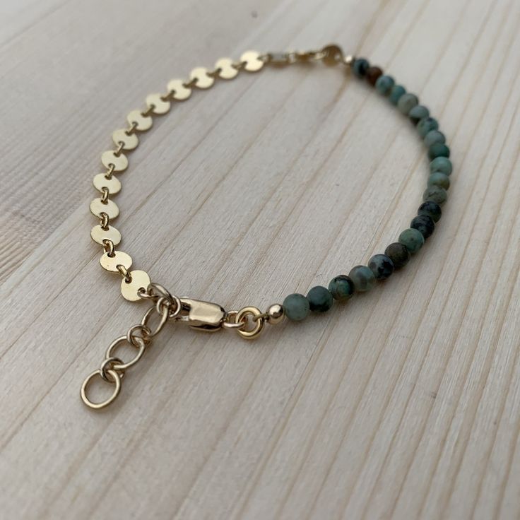 "This bracelet is super lightweight and delicate, but packs a big punch for being so petite. I love that it is a combo of smooth, subtle beads and bold, eye catching chain! The best of both worlds. Perfect for stacking up with other bracelets, or wearing alone. The high low bracelet is made from African turquoise beads, and either 14k gold fill or sterling silver coin chain and components. Since this is a handmade item, please allow for slight variations in your bracelet from those that you see Dainty Nickel-free 14k Gold-filled Bracelets, Dainty 14k Gold-filled Nickel-free Bracelet, Dainty 14k Gold Filled Nickel-free Bracelet, Adjustable Bohemian Bracelet With Delicate Chain, Adjustable Dainty Green Chain Bracelet, Green Bracelet With Adjustable Chain, Elegant Turquoise Bracelets With Adjustable Chain, Green Bracelets With Adjustable Chain, Elegant Turquoise Bracelet With Adjustable Chain