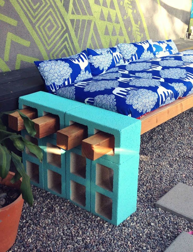 a bench made out of wooden blocks in front of a wall