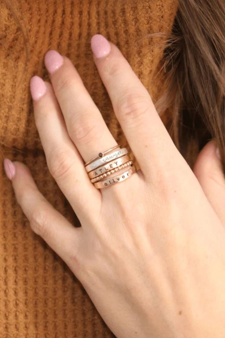 Stunning stacking name rings set, including a personalized name ring and dainty spacer rings. This gold and silver name ring set is a great gift for mom or grandma! Discover our beautiful kids name ring stacks, the perfect sentimental gift for mom's birthday or moms-to-be! These stackable kids name rings are the perfect simple meaningful jewelry pieces to add to your collection. Shop all of our custom personalized jewelry and silver name rings here! Classic Stackable Rose Gold Initial Ring, Classic Rose Gold Stackable Initial Ring, Adjustable Stackable Initial Ring, Adjustable Stackable Initial Ring For Everyday, Rose Gold Sterling Silver Stackable Rings With Birthstone, Silver 14k Gold Stackable Initial Ring, Everyday 14k Rose Gold Initial Ring, Dainty Engraved Rose Gold Ring With Round Band, Everyday Rose Gold 14k Initial Ring