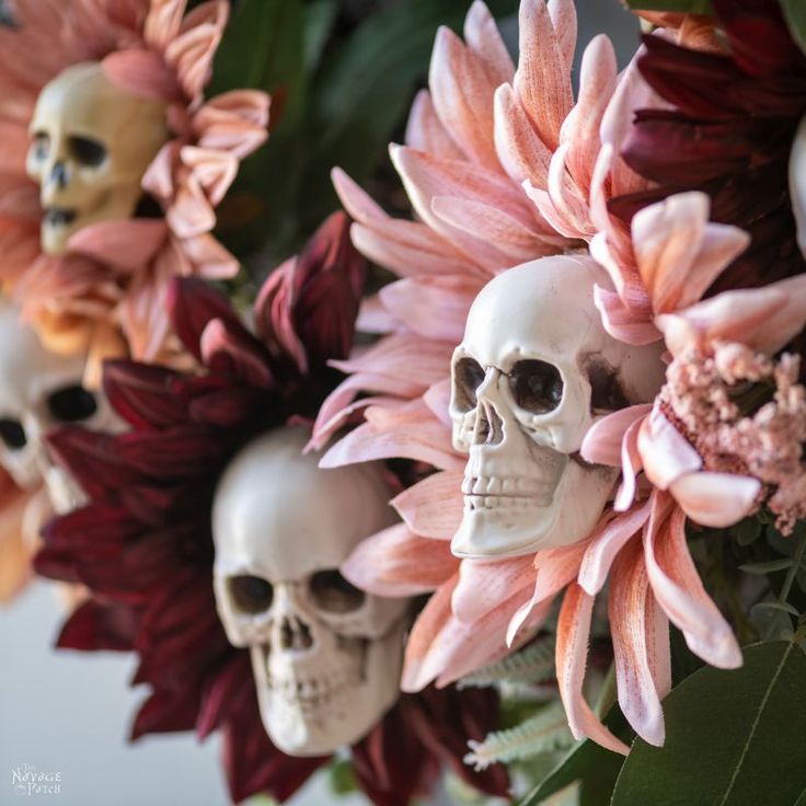 there are many skulls and flowers in the vase