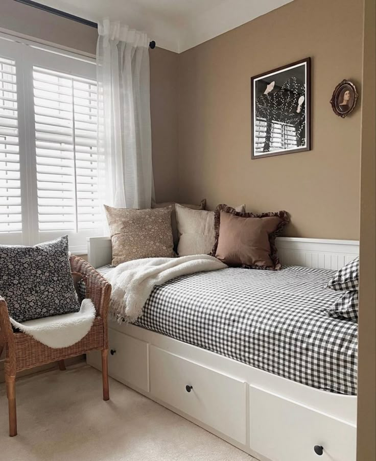 a bed sitting under a window next to a chair