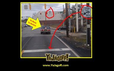 a car driving down a street next to a traffic light with an arrow pointing in the opposite direction