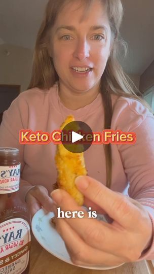 a woman holding a piece of food in front of her face with keto chicken fries on it