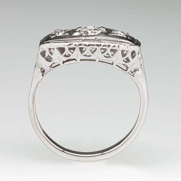 This lovely circa 1930s ring features an 14K white gold gallery with a pierced design that is centered with one (1), bead set, old European cut diamond and flanked to one side by one (1), bead set, old European cut diamond and to the other side by one (1), bead set, round brilliant cut diamonds. The ring has a 10K white gold shank. The ring measures 8.0mm at the top, rises 4.9mm above the finger, tapering to 1.9mm wide and 1.3mm thick at the base of the shank. This ring is currently a size 4.5. Antique Platinum Three Stone Diamond Ring, Antique Platinum Three-stone Jewelry, Estate Style Diamond Cut Rings For Formal Occasions, Art Deco Three Stone Round Ring, Estate Style White Gold Ring, Heirloom Three-stone Platinum Jewelry, Antique Platinum Three Stone Rings, Antique Three Stone Platinum Rings, Antique Three Stone Diamond Ring For Formal Occasions