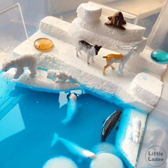 there are many toy animals on the ice in the water pool that is made to look like they're swimming