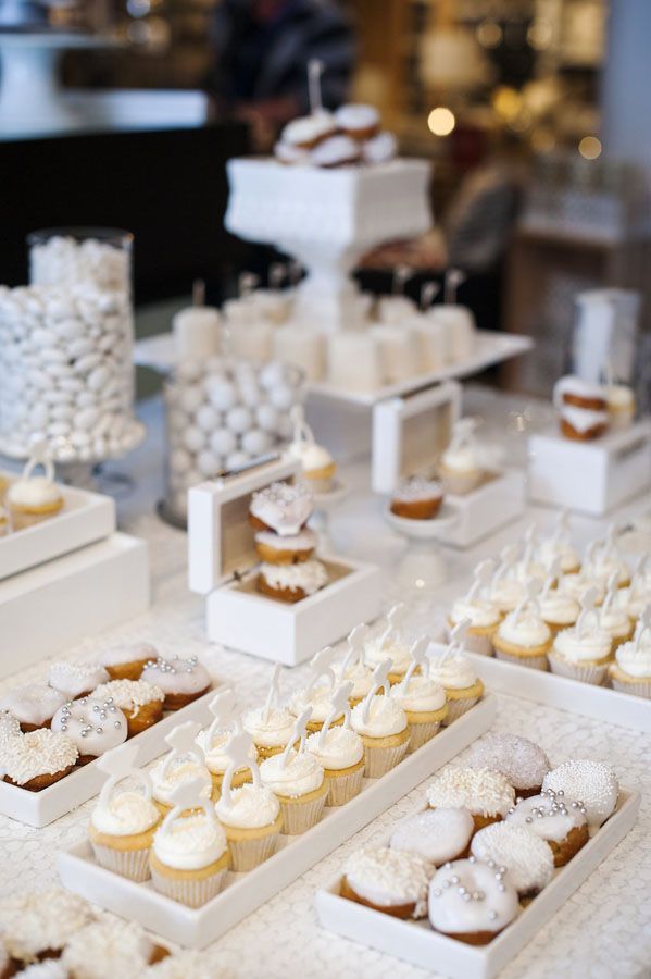 a table topped with lots of cupcakes covered in frosting