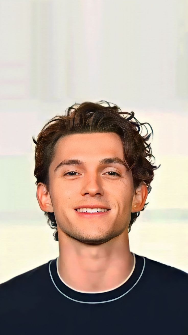 a young man with curly hair smiling at the camera while wearing a black t - shirt