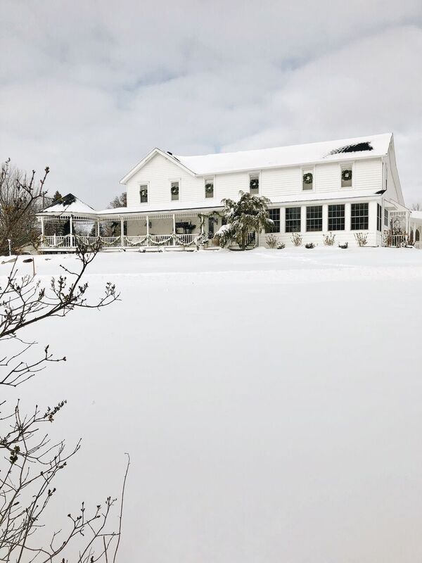 a large white house sitting on top of a snow covered field