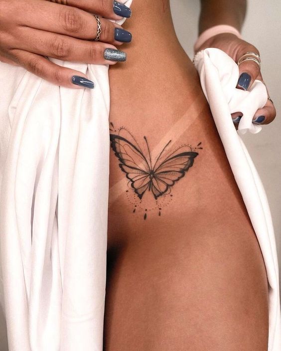 a woman's stomach with a butterfly tattoo on her left side ribcage