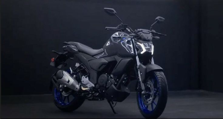 a black and blue motorcycle parked in a dark room