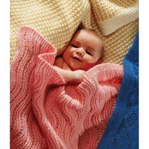 a baby wrapped in a blanket on top of a bed