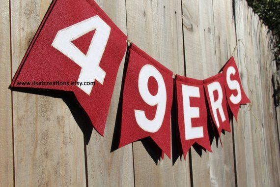 a red and white banner with the number nine on it hanging from a wooden fence