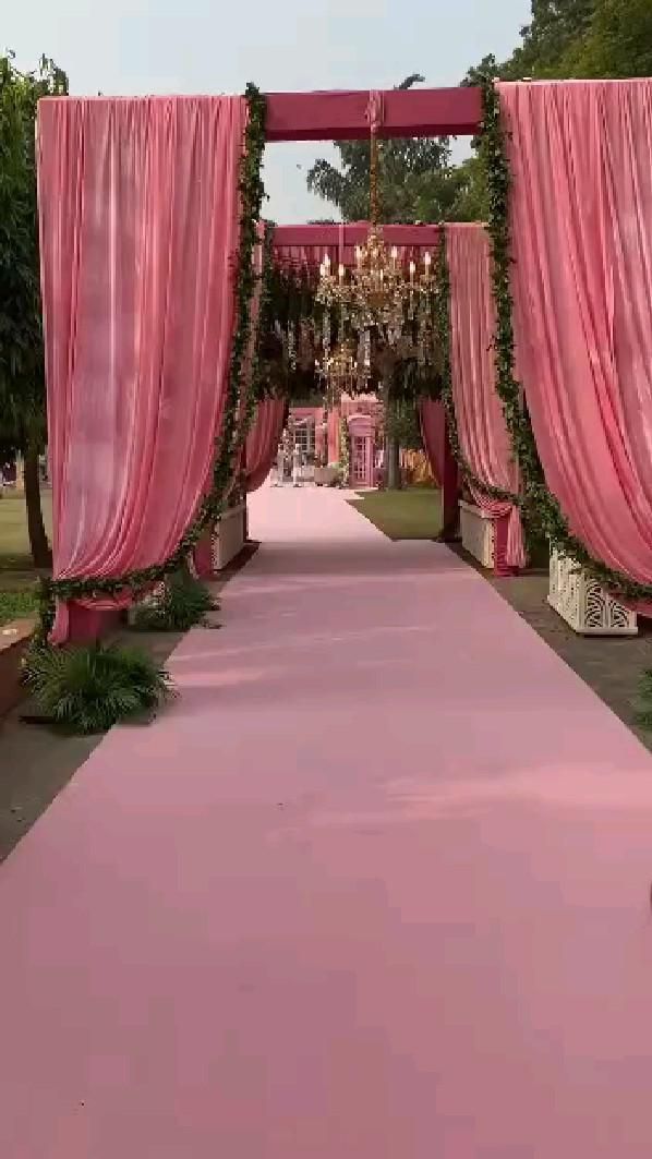 an outdoor ceremony with pink drapes and chandeliers