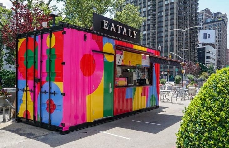 a colorfully painted food stand in the middle of a city