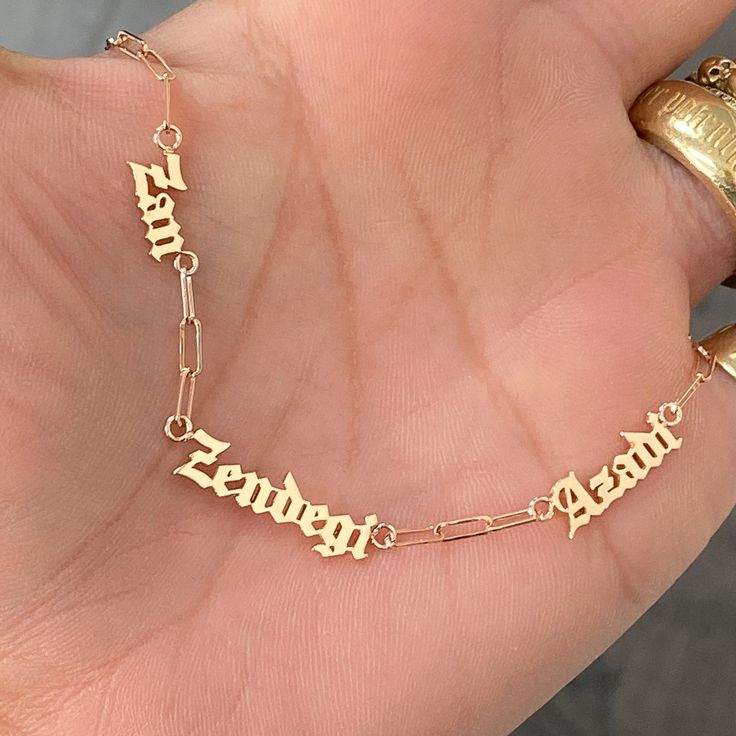 This meaningful necklace stating in Farsi "Woman Life Freedom" is made in support of the current Iranian movement for human rights. This nameplate cut-out necklace is composed entirely of 14K solid gold and beautifully complemented by a durable 14K solid gold chain small size paperclip chain. English Transliteration: Zan Zendegi Azadi Dimensions: approximately 7mm (L) to 11mm (L) Chain Width: approximately 2mm Pendant Thickness: approximately 1mm Metal Finish: High Shine Polish This design is av Customized Yellow Gold Pendant Name Necklace, Elegant Customizable Gold Plated Necklaces, Customized Yellow Gold Pendant Necklace, Customized Yellow Gold Sterling Silver Name Necklace, Custom Gold Nameplate Jewelry, Customized Yellow Gold Necklace For Anniversary, Customized 14k White Gold Necklace, Customized Nameplate Jewelry In White Gold, Customized Yellow Gold Nameplate Jewelry