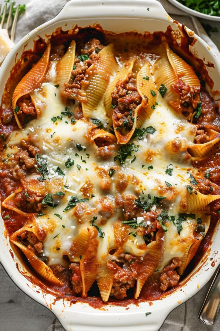 a white casserole dish filled with pasta and meat