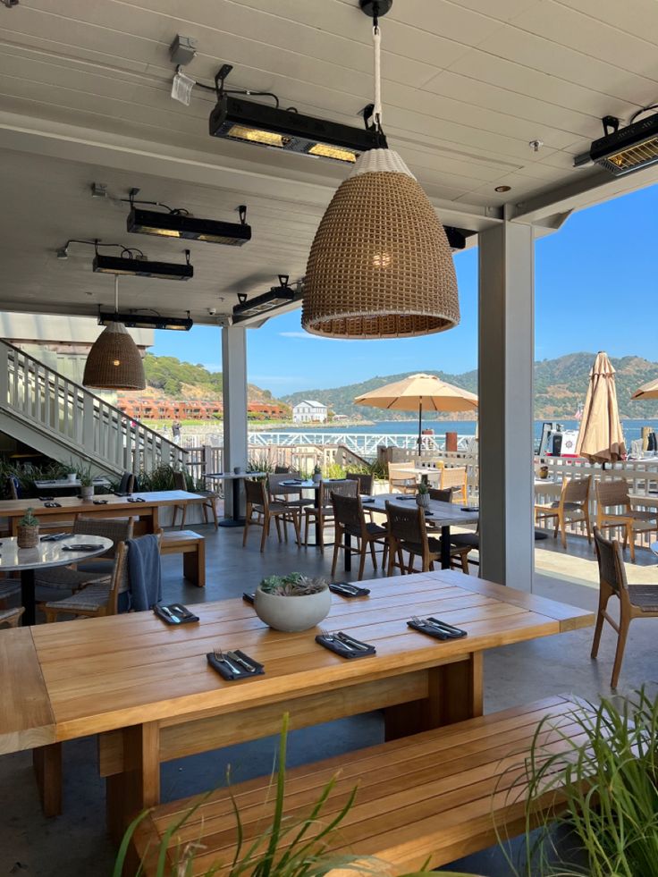 an outdoor dining area with wooden tables and chairs