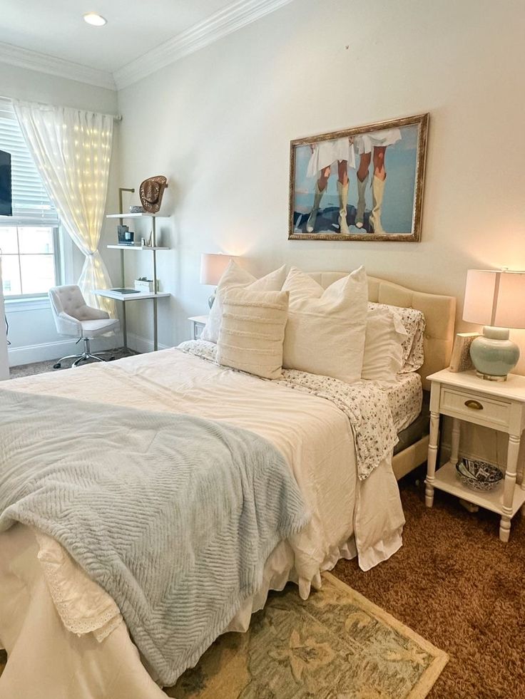 a bed sitting in a bedroom next to a window covered in white sheets and pillows