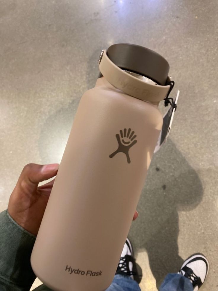 a person holding a hydro flask in their hand