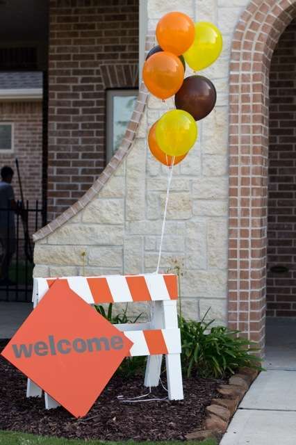 a welcome sign with balloons attached to it