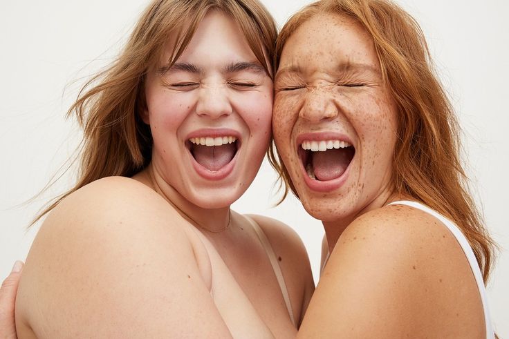 two women with freckled hair are hugging each other and one has her eyes closed