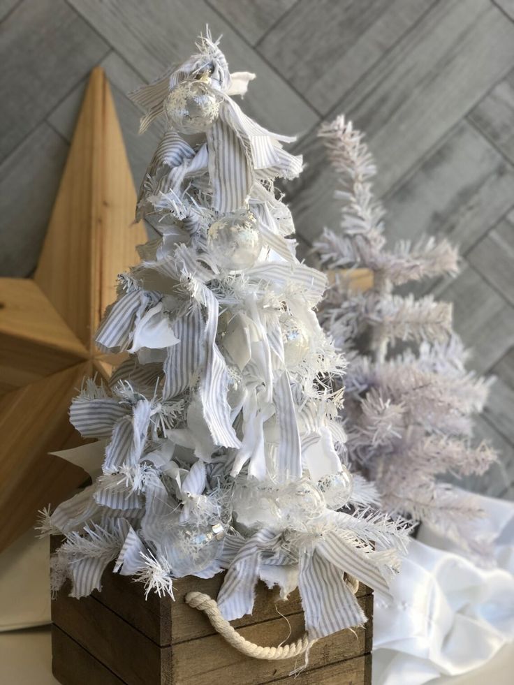 a white christmas tree sitting on top of a wooden box