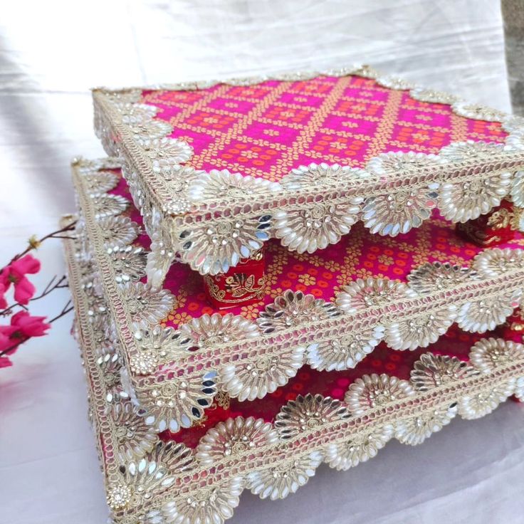 three pink and white decorative trays on a table with flowers in the foreground