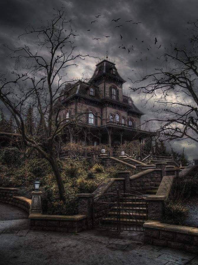 an old house with stairs leading up to it and bats flying in the sky above