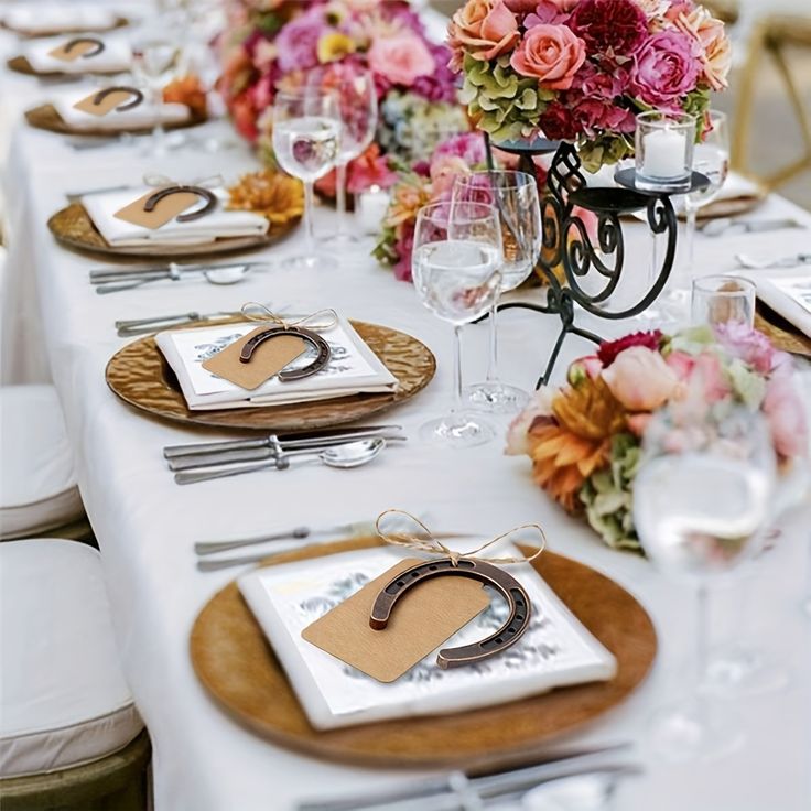 the table is set with flowers and place settings