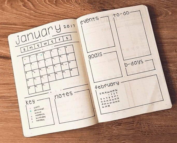 an open planner book sitting on top of a wooden table