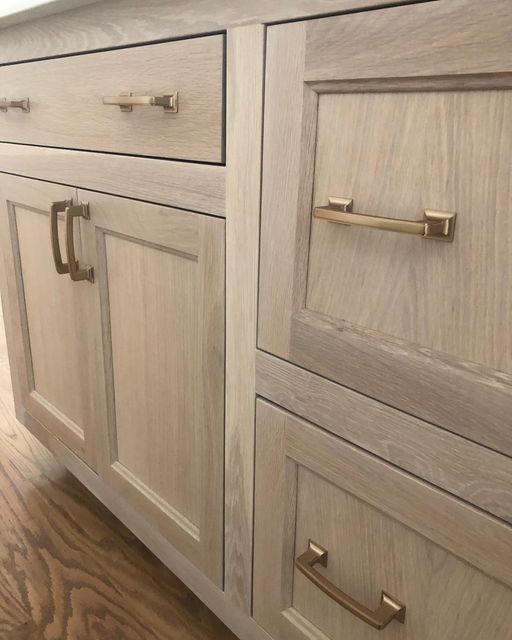 a close up of a wooden cabinet with brass handles