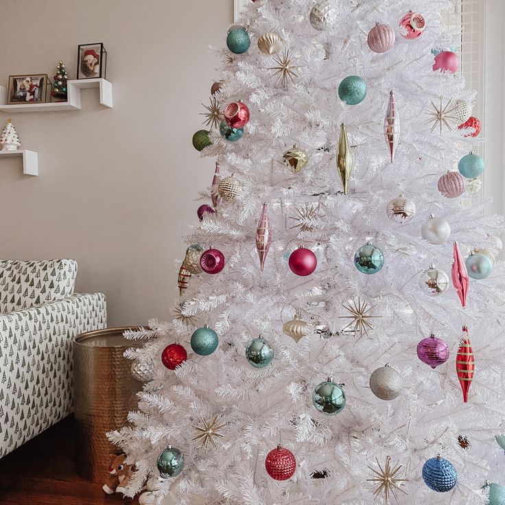 a white christmas tree with ornaments on it