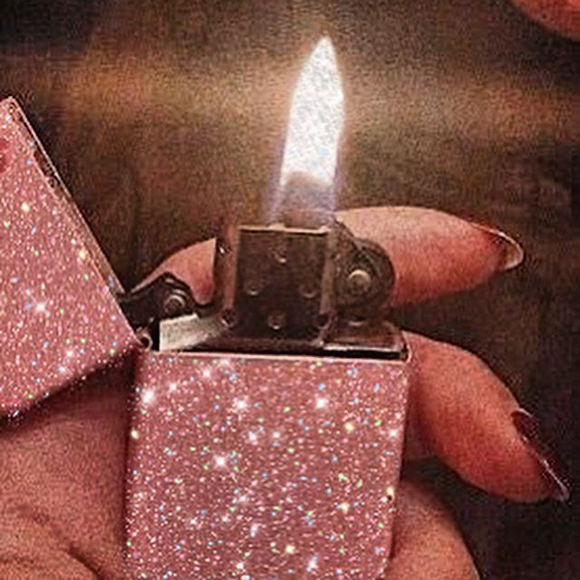 a person holding a pink lighter in their hand with sparkles on the top and bottom