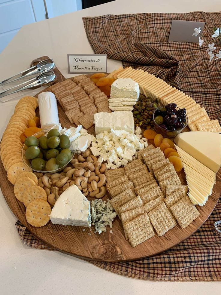 a wooden platter filled with cheese and crackers