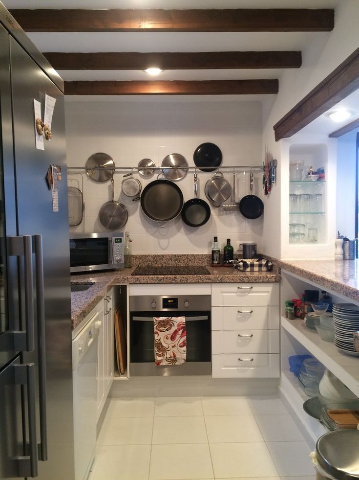 a kitchen with pots and pans hanging on the wall