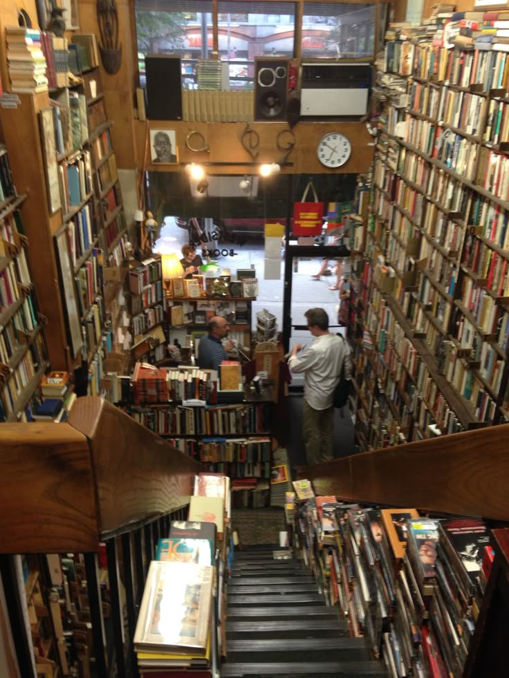 the stairs are full of books and there is a man standing in the doorway next to them