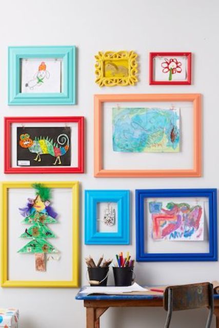 there are many colorful frames on the wall with children's drawings and artwork in them