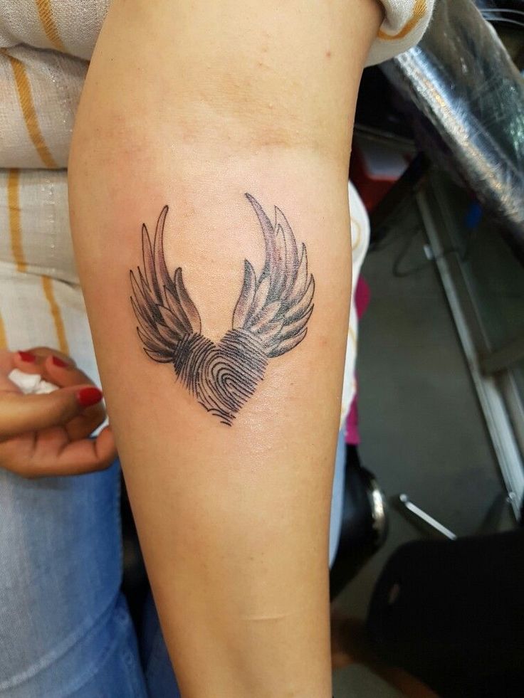 a woman's arm with a tattoo on it that has a bird in the middle