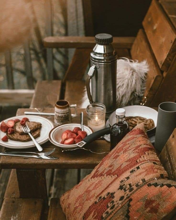 a wooden table topped with plates of food