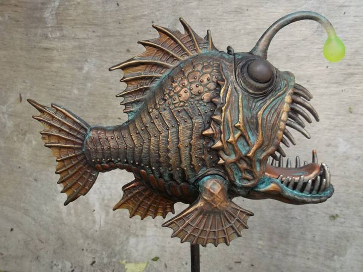 a metal fish sculpture sitting on top of a table