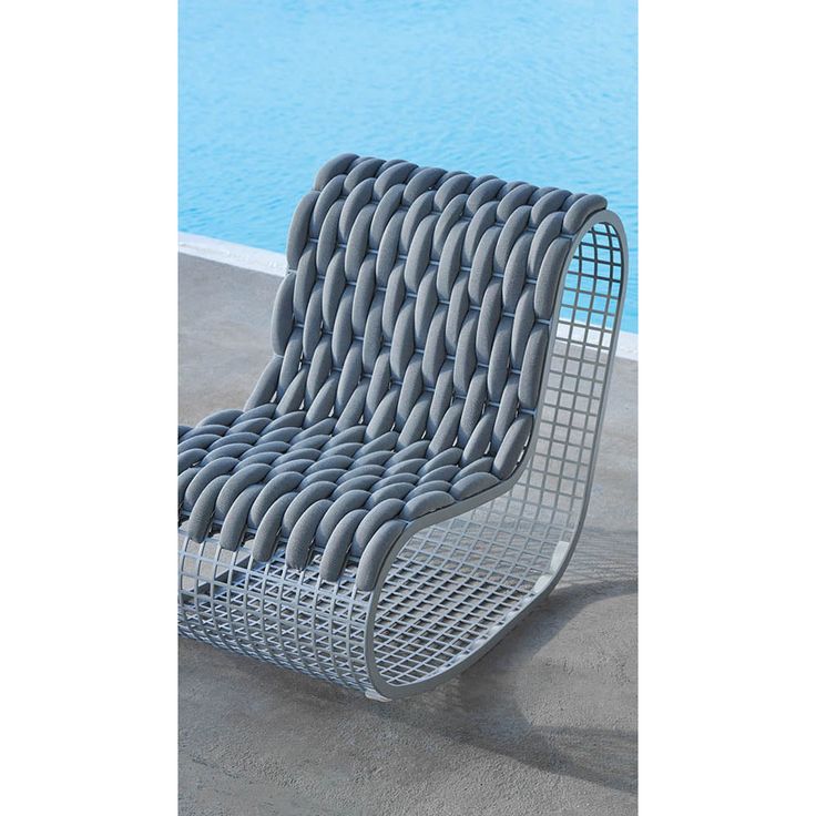 a metal chair sitting next to a pool with water in the backgrouds