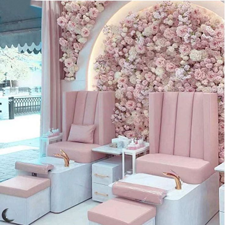 a room with pink chairs and flowers on the wall