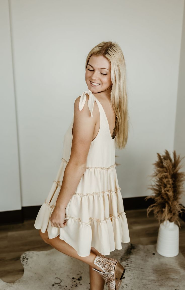 Step into carefree vibes with the Sundown Serenade Tiered Babydoll Dress. Made from textured crepe fabric, this boho-inspired dress features tiered ruffles for a playful, flowy silhouette that dances with every step. The adjustable tie straps allow for a customizable fit, making it perfect for sunny beach days or warm nights out. With its wide bottom sweep, this dress adds an effortlessly feminine touch to any occasion. Whether you're strolling through a farmers' market or heading to a casual su Boutique Aesthetic, Tiered Babydoll Dress, Western Boutique, Sunny Beach, Beach Days, Inspired Dress, Crepe Fabric, Babydoll Dress, Sweater Blouse